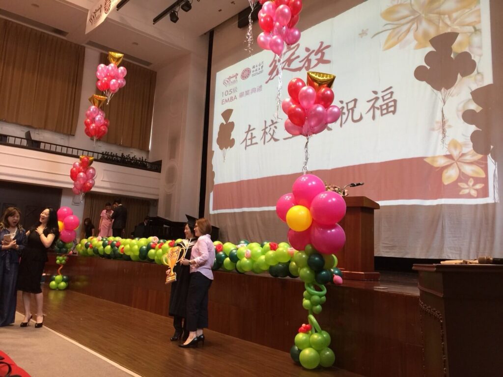 台北師範大學典禮氣球佈置，以藍白弧形氣球頂結構與舞台光線呼應學術氛圍