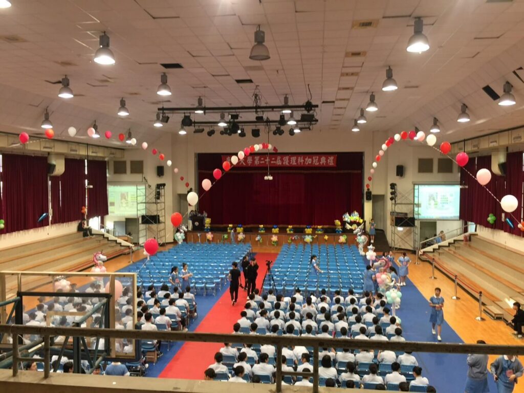 台北康寧大學加冠典禮場地佈置，以白金與淡藍弧形氣球頂結構打造典禮氛圍