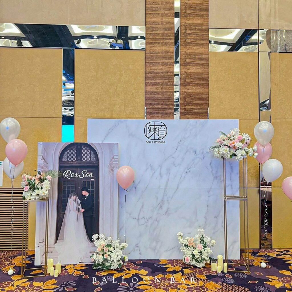 迎賓牆可融入新人的英文名縮寫、婚禮主題色，或以立體幾何結構、弧形氣球框圍塑拍照背景